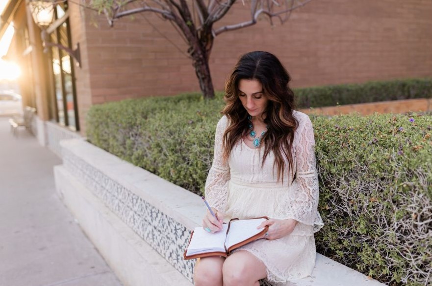 Kaleena Shreeve sitting writing in notebook